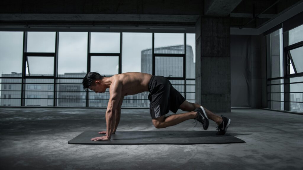 Hombre haciendo plancha en gimnasio moderno ejercicio intenso